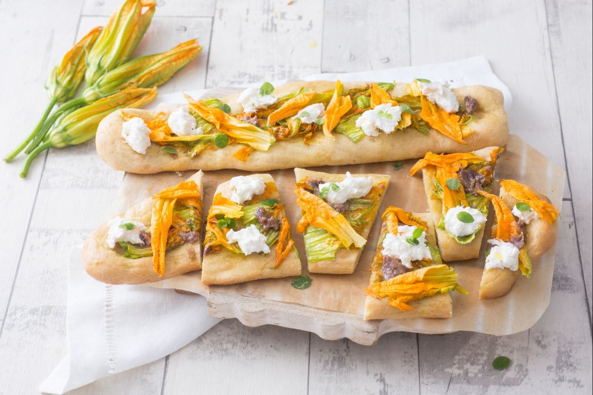Focaccia com anchovas, flores de abóbora e burrata
