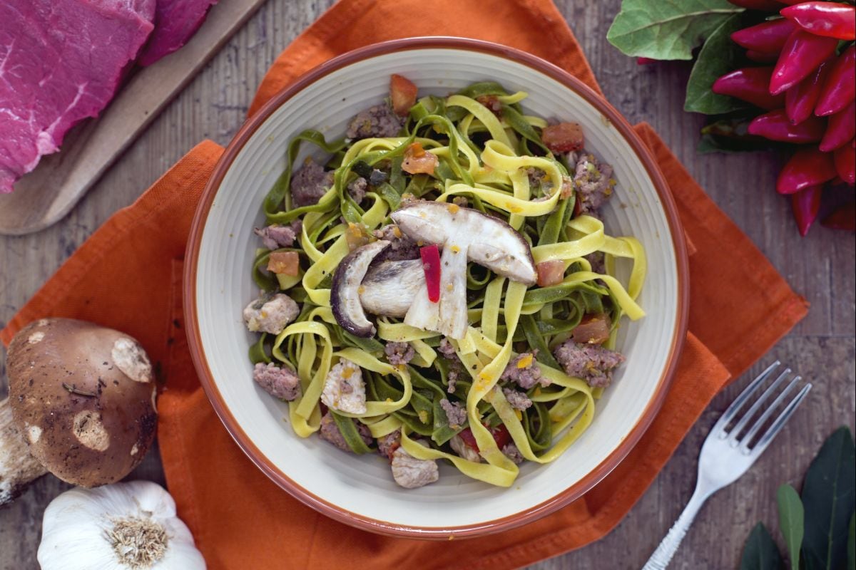 Paglia e fieno com carnes mistas e cogumelos
