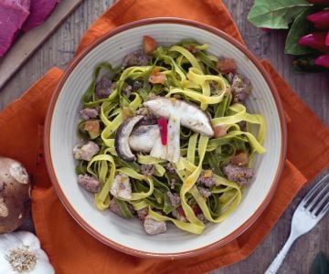 Paglia e fieno com carnes mistas e cogumelos