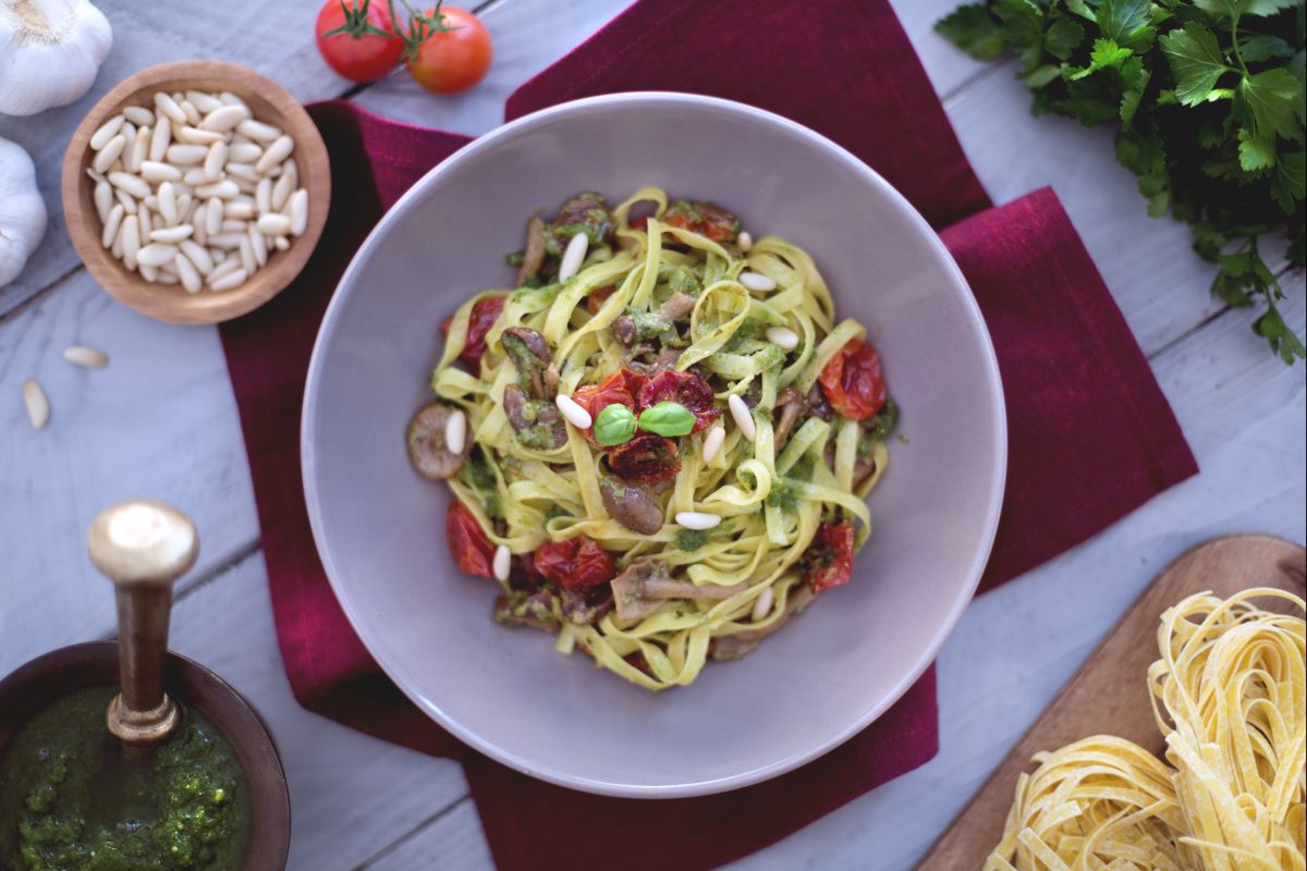 Tagliatelle com tomatinhos confit, cogumelos chiodini e pesto