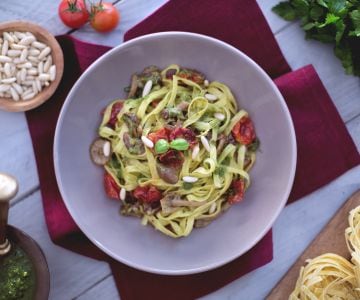 Tagliatelle com tomatinhos confit, cogumelos chiodini e pesto