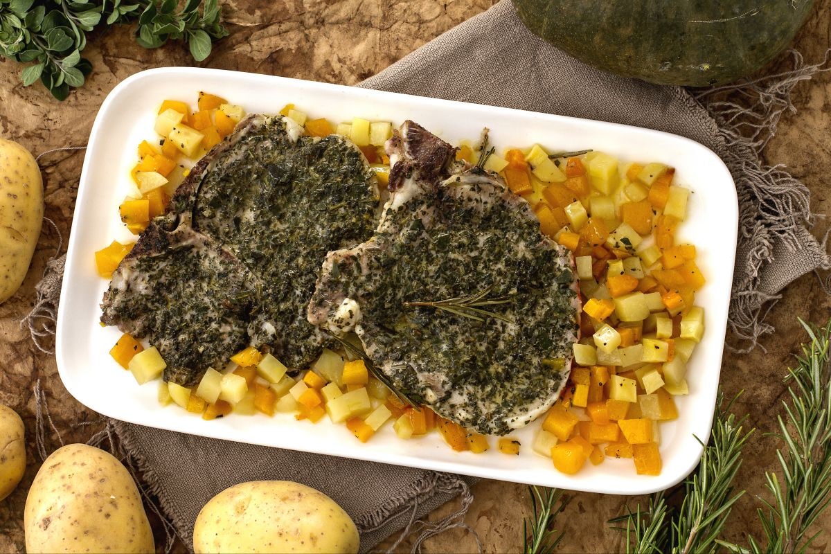 Costeletas de porco com ervas, abóbora e batatas