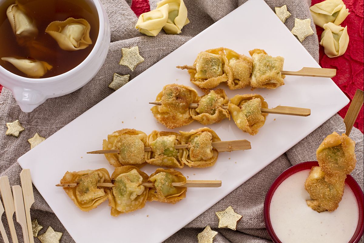 Espetinhos de tortellini fritos com molho de creme de leite e parmesão