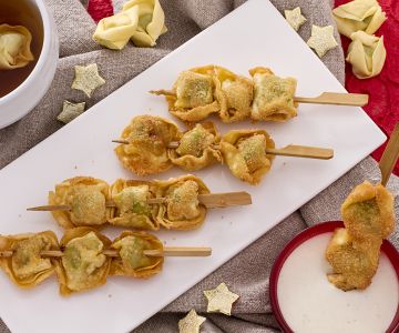 Espetinhos de tortellini fritos com molho de creme de leite e parmesão