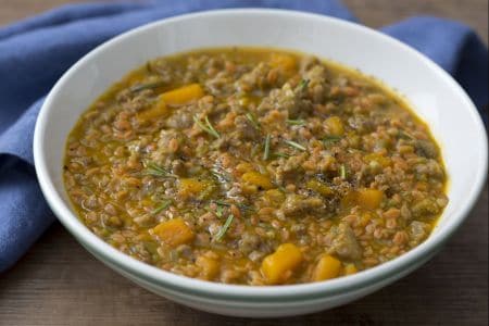 Grãos de farinha de leguminosas com linguiça e abóbora na cerveja