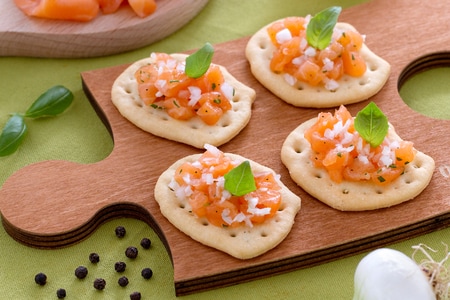 Pães achatados com tártaro de salmão e cebolinha