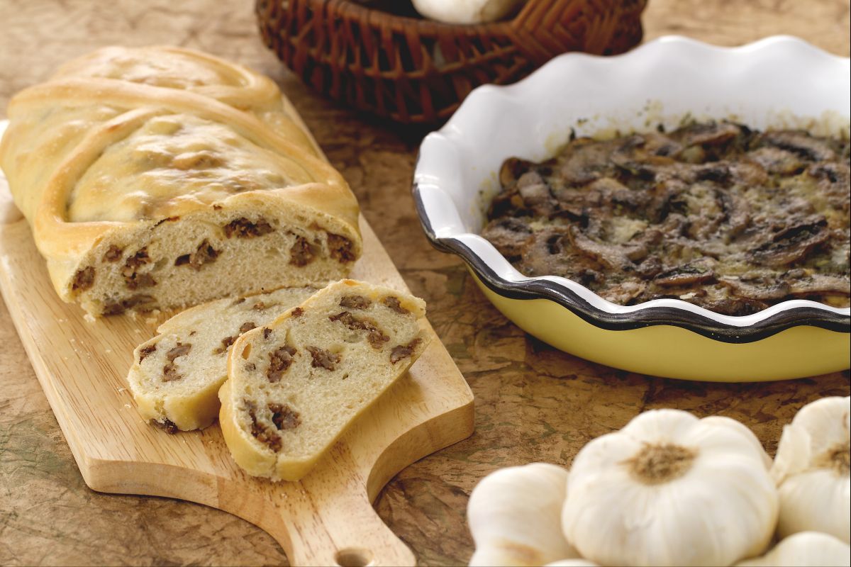 Strudel de pão recheado com linguiça e travessa de cogumelos saborosos