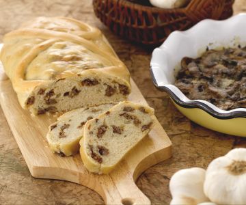 Strudel de pão recheado com linguiça e travessa de cogumelos saborosos