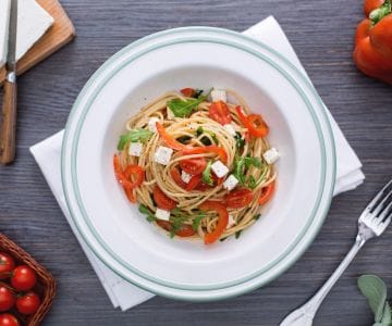 Espaguete integral com pimentões vermelhos, rúcula e feta