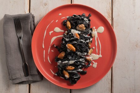 Tagliatelle ao negro de sépia com pecorino, mexilhões e bacon