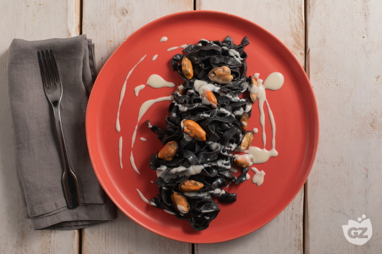 Tagliatelle ao negro de sépia com pecorino, mexilhões e bacon