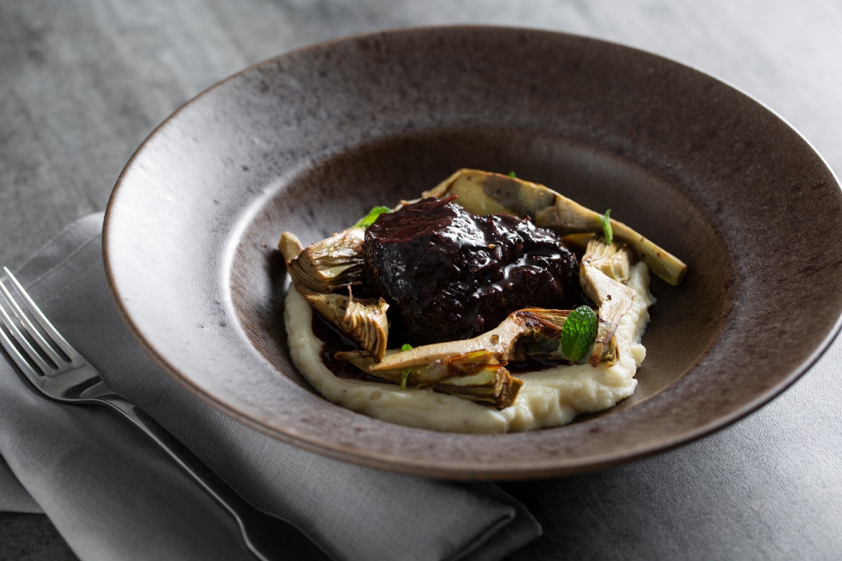 Bochecha de boi com alcachofras