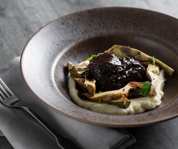 Bochecha de boi com alcachofras