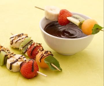 Espetinhos de fruta com molho de chocolate e granulado de avelãs