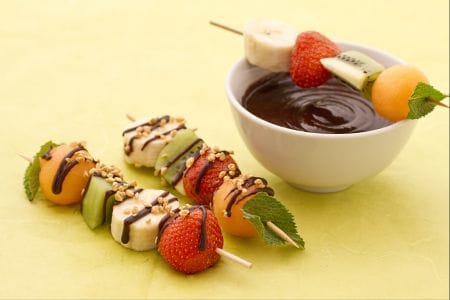 Espetinhos de fruta com molho de chocolate e granulado de avelãs