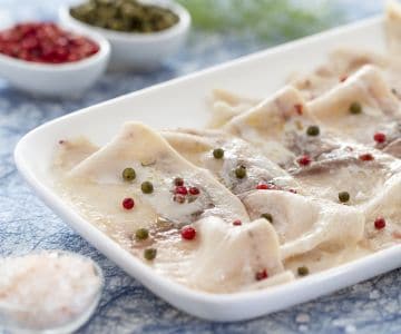 Carpaccio de peixe-espada com pimenta verde e rosa