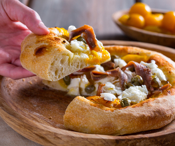 Pizza com tomatinhos amarelos, anchovas e alcaparras