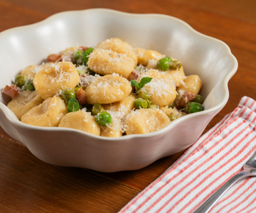 Nhoque de ricota com ervilhas, pecorino e guanciale