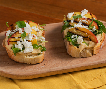 Torrada com homus, pêssegos grelhados, feta e rúcula
