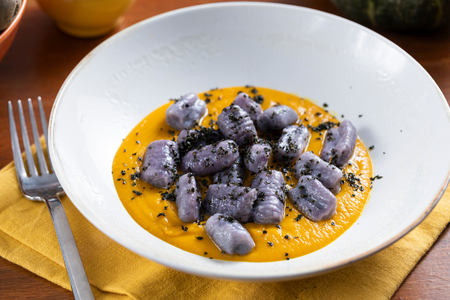 Nhoque de batata roxa com creme de abóbora e couve