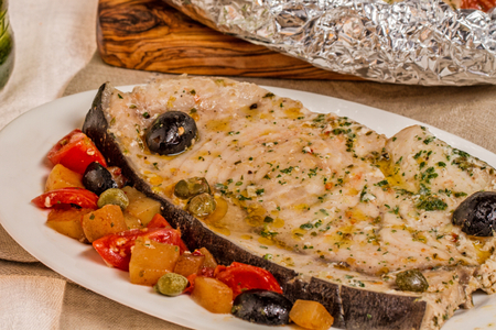 Peixe-espada no papelote com cerveja, tomatinhos e azeitonas