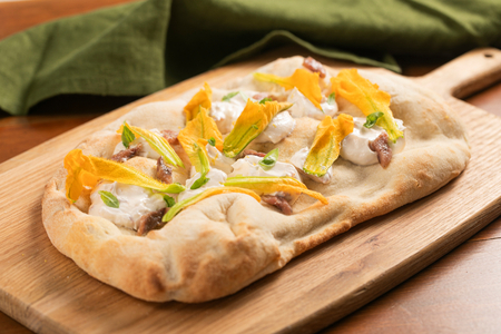 Pinsa com flores de abobrinha, anchovas e creme de queijo