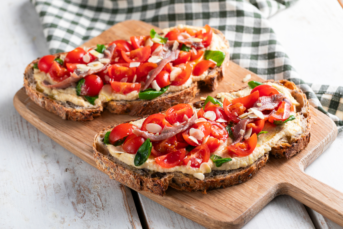 Bruschetta com tomatinhos, homus e anchovas