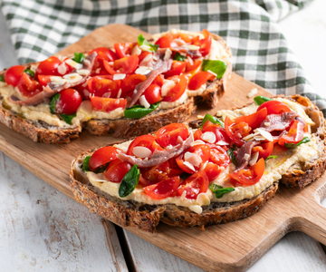 Bruschetta com tomatinhos, homus e anchovas