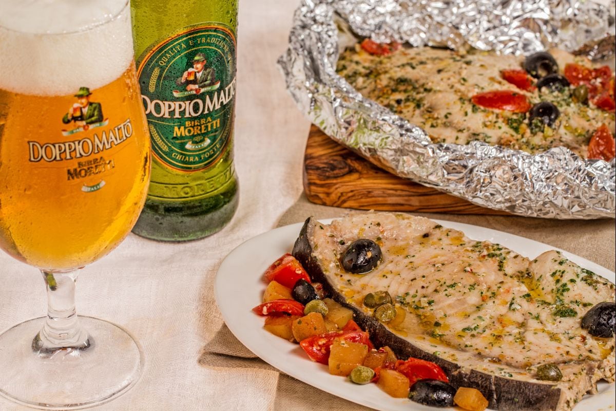 Peixe-espada no papelote com cerveja, tomatinhos e azeitonas
