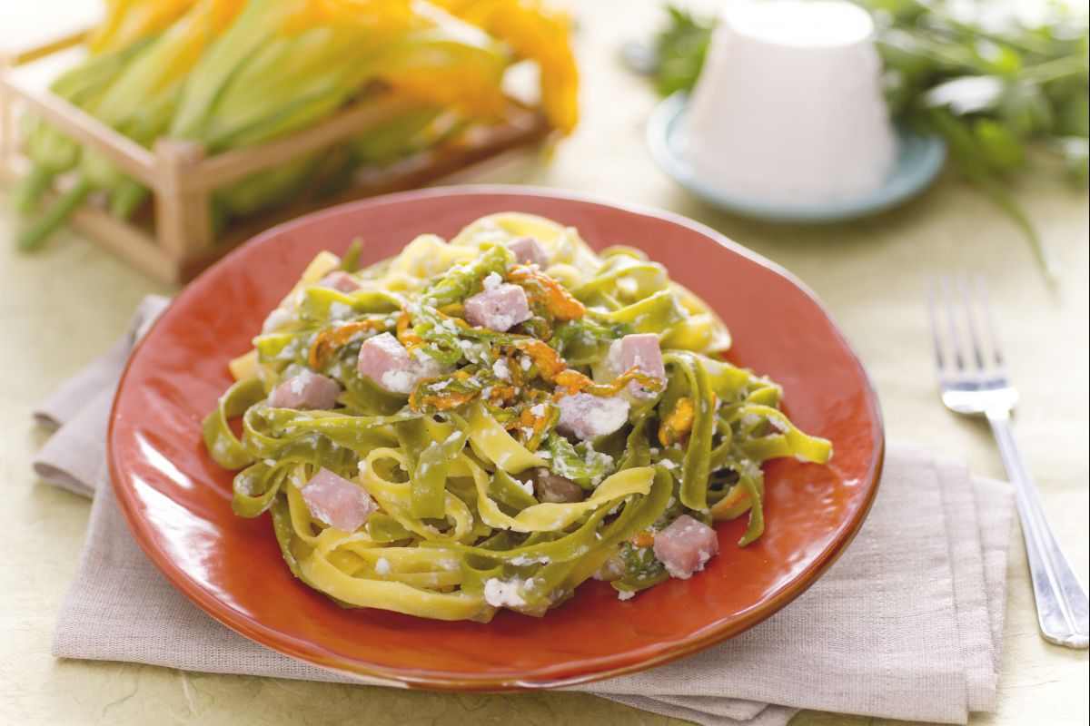 Paglia e fieno com creme de ricota, flores de abóbora e cubos de presunto