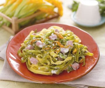 Paglia e fieno com creme de ricota, flores de abóbora e cubos de presunto