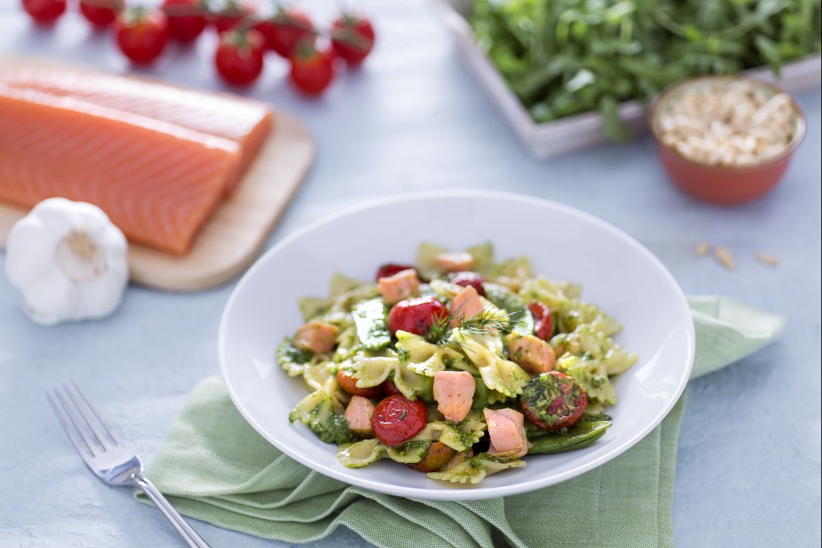 Farfalle com salmão, ervilhas-tortas e tomates-cereja confitados com pesto de rúcula