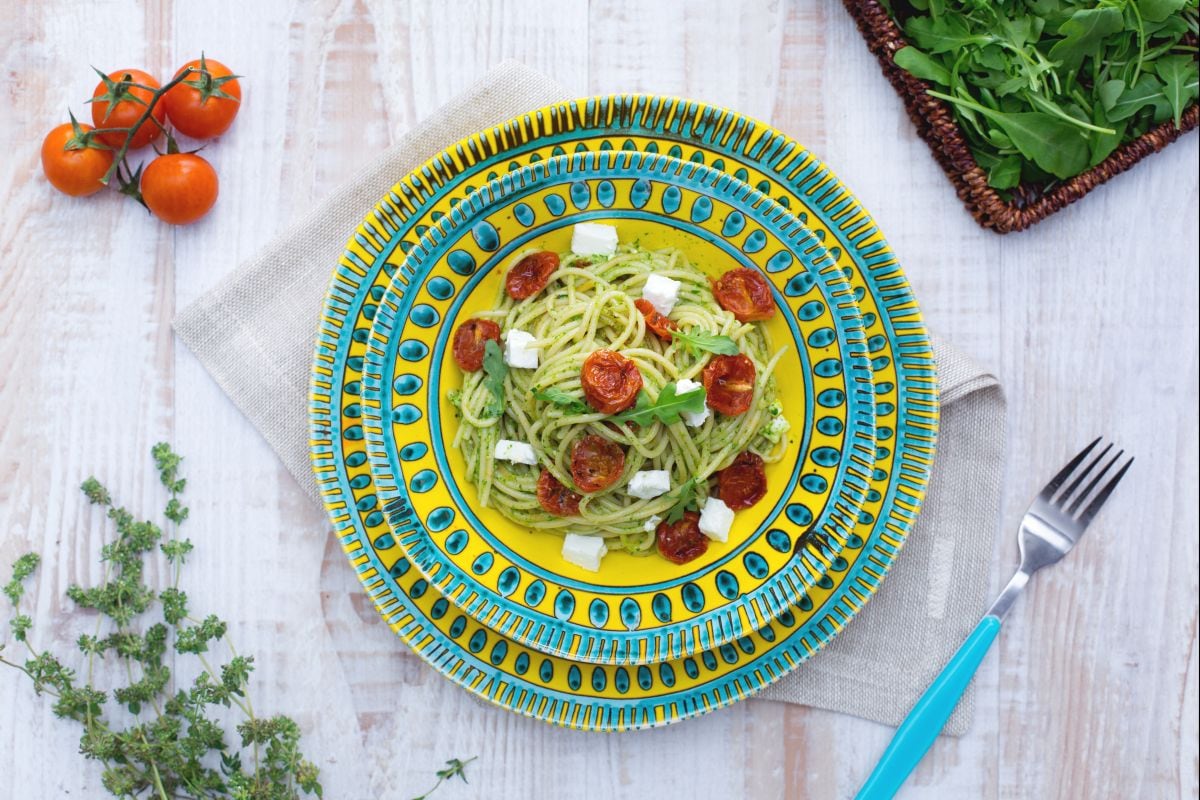 Espaguete integral com tomatinhos confit, feta e pesto leve de rúcula