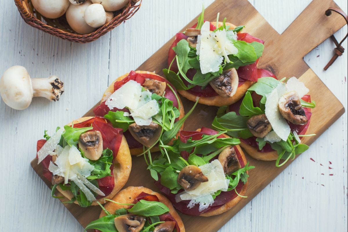 Pãezinhos achatados com bresaola e rúcula